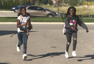two girls smiling while running